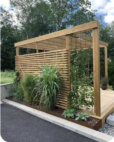 a wooden gazebo surrounded by plants and rocks