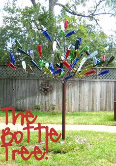 there is a tree made out of wine bottle caps in the yard with the words the bottle tree on it