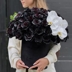 a woman holding a bouquet of flowers in her hands