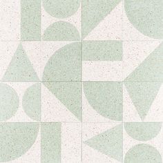 a white and green tile pattern with circles and triangles on it's side,