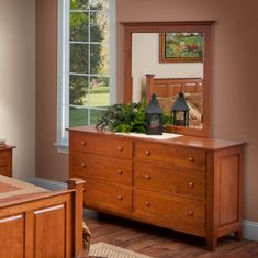 a bedroom scene with focus on the dresser and mirror