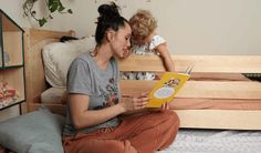 a woman sitting on top of a bed next to a child