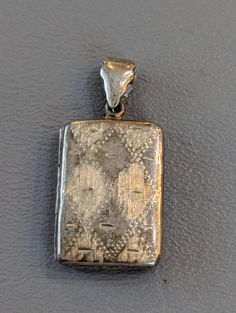 "Vintage etched Sterling Silver book locket. Locket will hold two pictures and can be engraved with a personal message on reverse side. Locket is fully hallmarked and will arrive gift boxed. * HALLMARKS A925. * MEASUREMENTS 1 1/2\" x 3/4\". * WEIGHT 7.23 Grams. * CONDITION In very good to excellent condition. * MATERIALS Sterling Silver." Rectangular Engraved Antique Silver Jewelry, Engraved Rectangular Pendant Locket Necklace Gift, Rectangular Engraved Locket Necklace As A Gift, Engraved Rectangular Locket Necklace Gift, Engraved Rectangular Locket Necklace For Gift, Silver Etched Locket Necklace For Memorial, Rectangular Locket Jewelry For Keepsake, Collectible Etched Rectangular Jewelry, Heirloom Silver Rectangular Jewelry