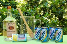 an assortment of drinks and condiments sitting on a table with trees in the background