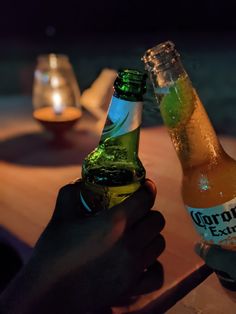 two bottles of beer sitting on top of a wooden table next to eachother