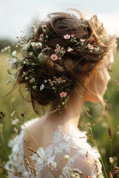 a woman with flowers in her hair is standing in the middle of tall grass and looking off into the distance