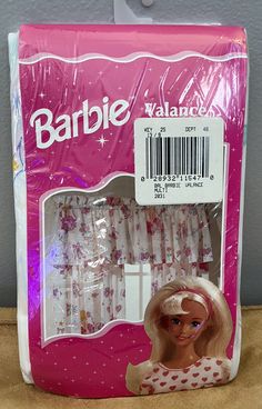 a barbie doll with pink hair and white dress on display in front of a package