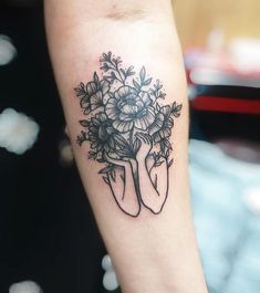 a woman's arm with flowers on it