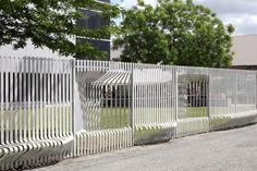 a white fence is next to a building