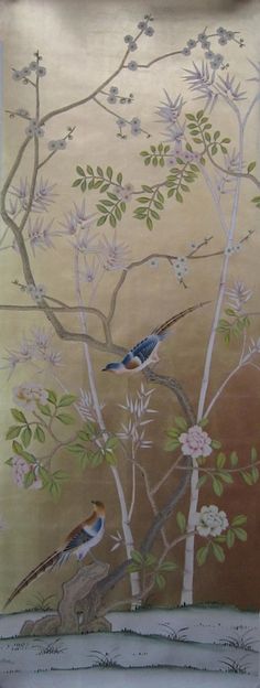 two birds sitting on top of a tree branch in front of a wall with flowers