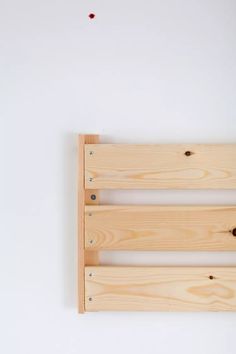 two wooden slats with holes in them on a white surface, one is empty and the other has red dots