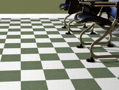 two desks and chairs are on a checkered floor