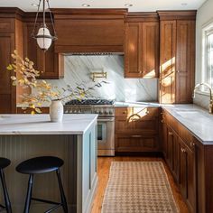 a kitchen with wooden cabinets and white counter tops, along with an area rug on the floor