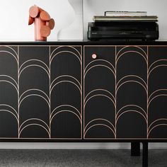 a black and gold sideboard sitting on top of a wooden table next to a record player