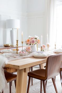 a dining room table with candles and flowers on it