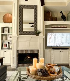 a living room filled with furniture and a fire place in front of a tv mounted on a wall