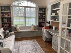 a living room filled with lots of furniture and bookshelves next to a window