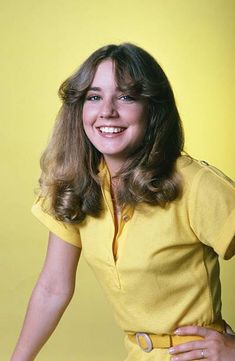 a woman in a yellow shirt posing for a photo