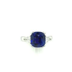 A stunning 4.53 carat cushion shape blue sapphire with exquisite "royal blue" color is set with two spectacular diamonds in this handmade platinum 3-stone engagement ring. Gemstones like this are in a class by themselves. With its deep blue color, exceptional clarity and excellent proportions, sapphires of this caliber are rare and highly sought after, even by gem dealers. This cushion measures 9.17 x 8.68 x 6.39mm is accompanied by Gemological Institute of America Origin Report #2205170372 whic Luxury Cushion Cut Three Stone Sapphire Ring, Luxury Three Stone Round Cut Sapphire Ring, Formal Three-stone Sapphire Ring In Platinum, Classic Three-stone Sapphire Diamond Ring, Luxury Platinum Sapphire Three-stone Ring, 3 Stone Engagement Rings, Stone Engagement, 3 Stone Rings, Royal Blue Color