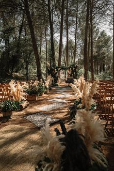 an outdoor ceremony setup with chairs and flowers in the foreground, surrounded by trees