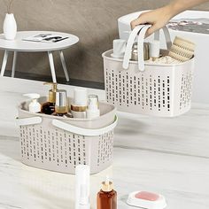 two white baskets filled with personal care items on a counter top next to a sink