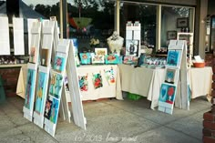 an outdoor art market with paintings on display