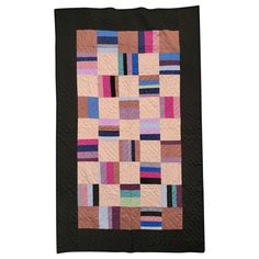 a pink and black quilt with squares on it