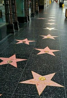 the star on the hollywood walk of fame is pink and gold with stars all over it