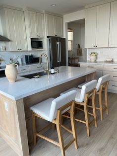 a kitchen island with four stools in front of it and an oven on the other side