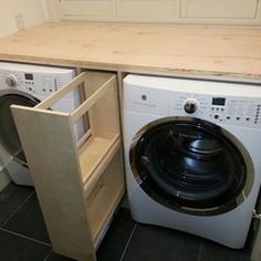 a washer and dryer in a small room next to a counter with an open door