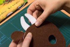 someone is cutting out a paper monkey mask