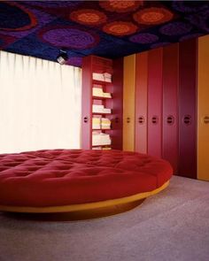 a round bed sitting in the middle of a room with lots of closets behind it