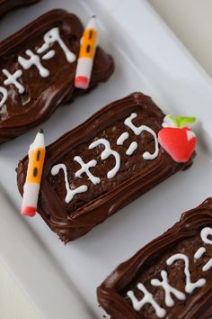 some chocolate treats with writing on them are arranged in the shape of an apple and two pencils