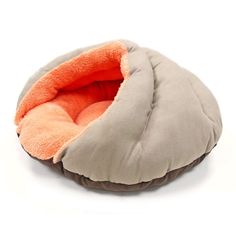 a dog bed with an orange and grey pillow on it's back end, in front of a white background