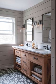 a bathroom with two sinks and three mirrors