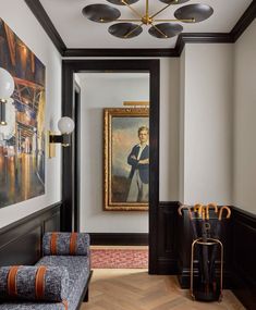 the hallway is decorated in black, white and gold with art on the wall behind it