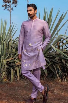 Lilac kurta hand embroidered with golden motifs and pleated collar. Comes with pant pyjama.
Components: 2
Pattern: Hand Embroidered, Hand Dyed
Type Of Work: Lotus, birds, leaves
Neckline: Mandarin
Sleeve Type: Full
Fabric: Kurta: Chanderi Silk, Pant Pyjama: Vegan Silk
Color: Purple
Other Details: 
Side pocketed pant
Disclaimer: The fabrics used, are handwoven, hence may have impurities or slubs/variation in the weave that beautifies the look and should not be considered as defect. The set is dye Lilac Mens Wedding Attire, Handpainted Mens Kurta, Lilac Kurta For Men, Sangeet Kurta For Men, Sangeet Outfit Men, Purple Kurta For Men, Silk Kurta For Men, Dino Skirt, Kurta Designs Men's