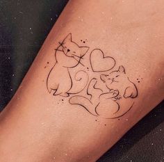 a small tattoo on the leg of a woman with two cats and hearts in it