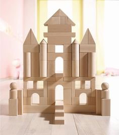 a wooden toy castle sitting on top of a hard wood floor