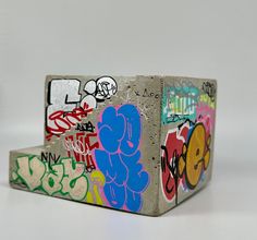 a box covered in graffiti sitting on top of a table