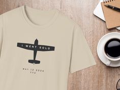 a t - shirt that says i went solo on it next to a cup of coffee