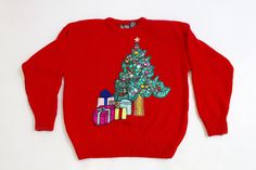 a red sweater with a christmas tree and presents on it