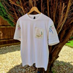 New design to my store ✨️  A plain white 100% cotton classic tshirt in a unisex size Large Unique modern tshirt with added Vintage linen fabrics.  The sleeves are made using a Vintage 1950s linen tablecloth that has delicate hand embroidered designs The patch on the front of the Tshirt is also Vintage 1950s embroidered linen  The tshirt itself is a very soft light cotton  Perfect for the warmer months with shorts or a skirt and then equally perfect for the cooler months under a Cardigan or jacke White Custom Embroidery Relaxed Fit Tops, White Tops With Custom Embroidery Relaxed Fit, White Relaxed Fit Top With Custom Embroidery, White Short Sleeve Top With Custom Embroidery, White Tops With Embroidered Text For Everyday, White Custom Embroidery T-shirt For Summer, White Everyday Top With Embroidered Text, White Embroidered Crew Neck T-shirt, Casual T-shirt With Custom Embroidery For Everyday