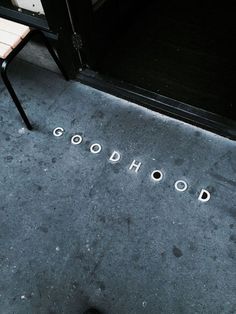 the word godhood is written on the sidewalk next to a chair and door way