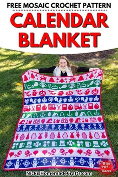 a woman sitting on the grass holding up a blanket that has been made to look like christmas