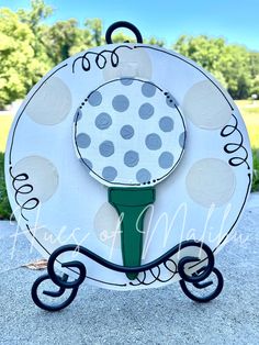 a paper plate that has a golf ball on it and wheels attached to the front