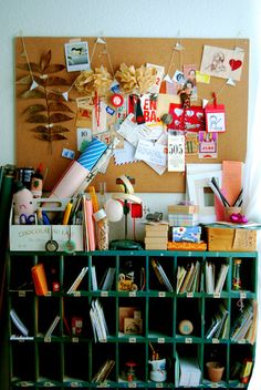 a bulletin board with lots of books and pictures hanging on it's side wall