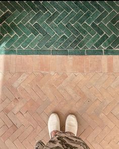 a person standing in front of a tiled floor