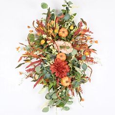 an arrangement of flowers and fruit on a white background