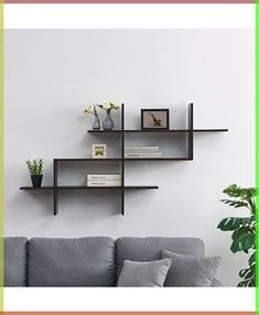 a living room with a gray couch and two shelves on the wall, one shelf is empty